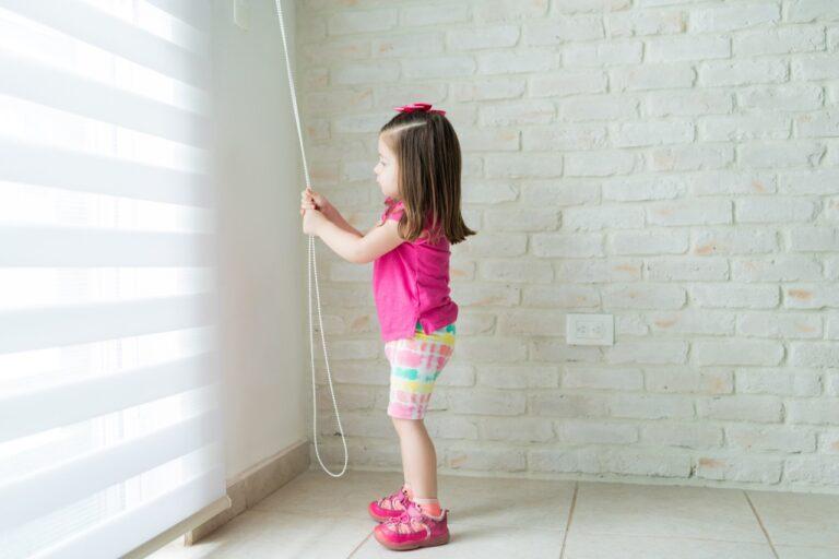 Child opening window shade with long hazardous loop.